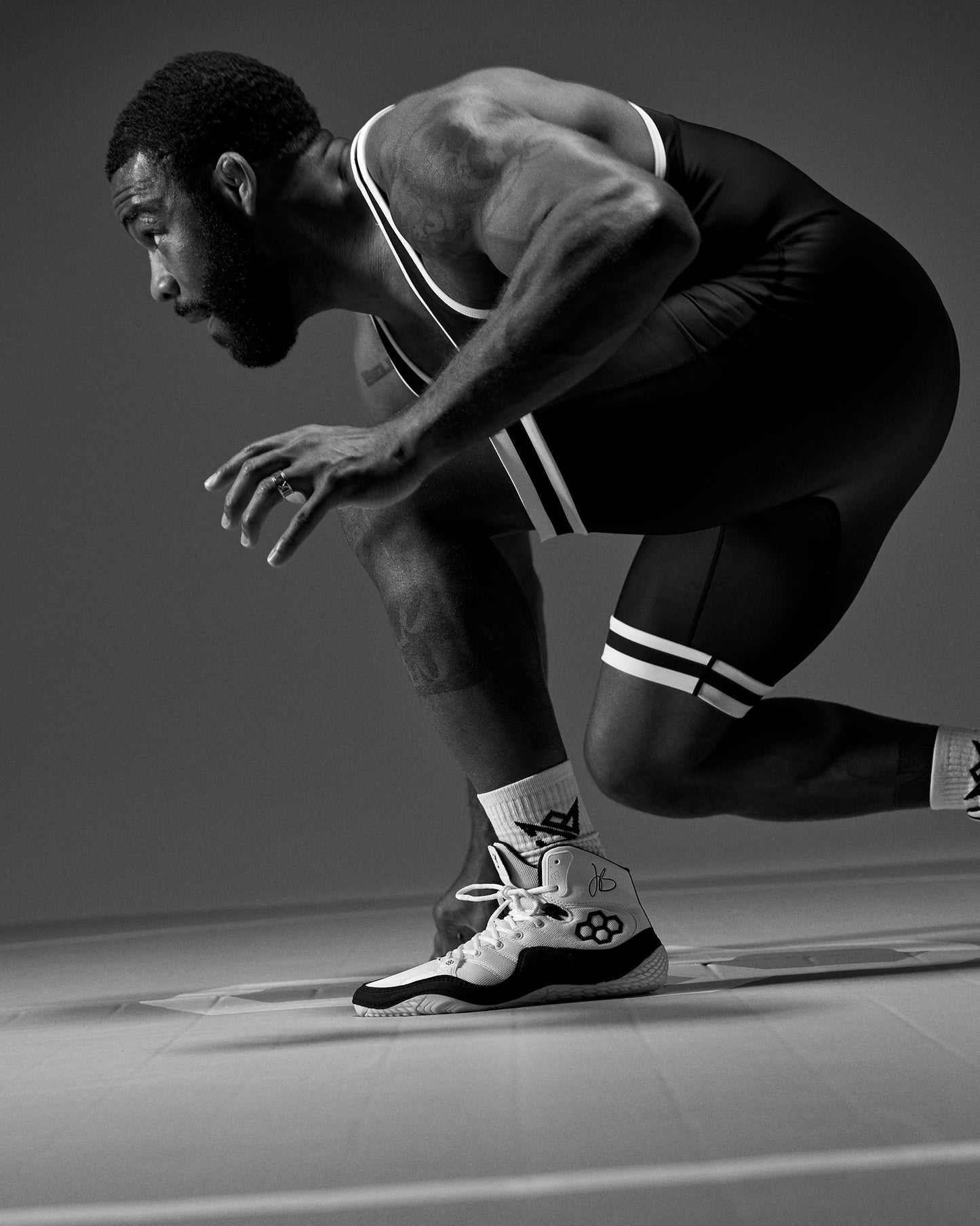 Black and white photo of a Jordan Burroughs Wrestling preparing on wrestling mat