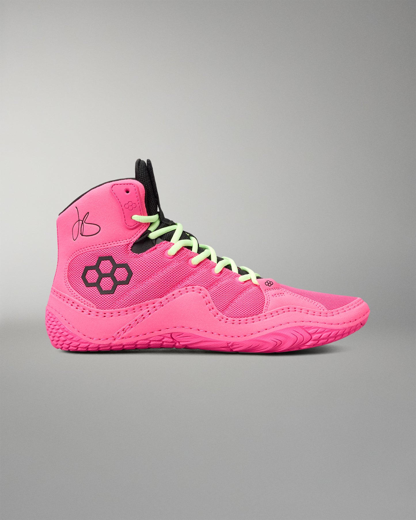 A high-top wrestling shoe in vibrant neon pink, featuring lime green laces, a black geometric logo on the side, and a black tongue label, set against a neutral gray background.