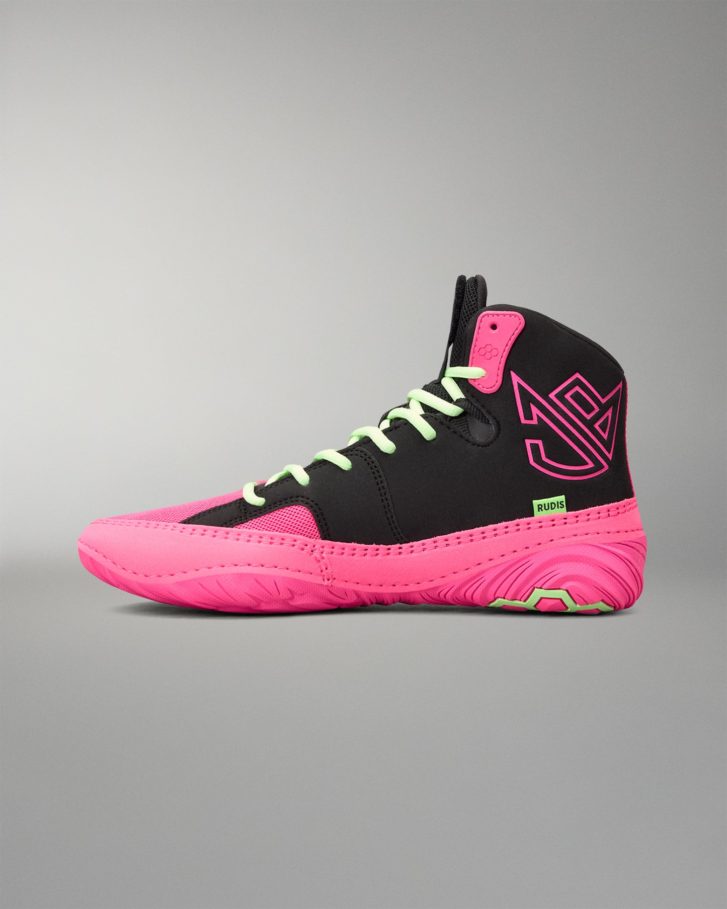 A high-top wrestling shoe in black and neon pink, featuring lime green laces and a small green 'RUDIS' logo on the side, set against a neutral gray background.
