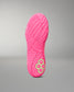 A bright pink wrestling shoe sole shown upright against a neutral gray gradient background, featuring a textured tread pattern and a small lime green hexagonal logo near the heel.