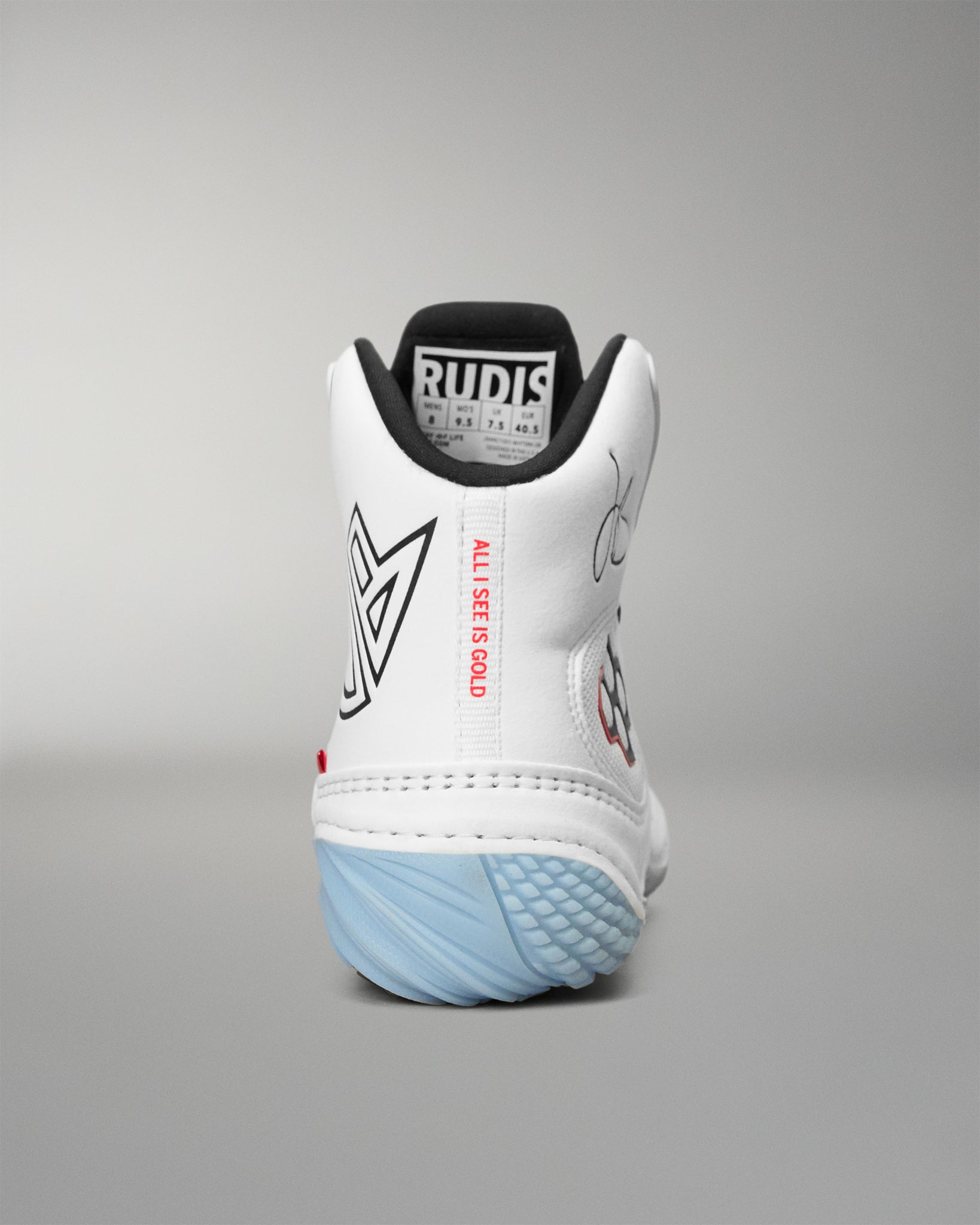 A white high-top wrestling shoes shown from the back, featuring a black collar, a light blue textured outsole, and graphic details including a black geometric logo, red text reading 'ALL I SEE IS GOLD', and a signature on the side.