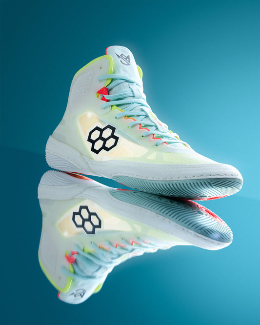 Colorful wrestling shoe with RUDIS brand logo on a reflective blue surface
