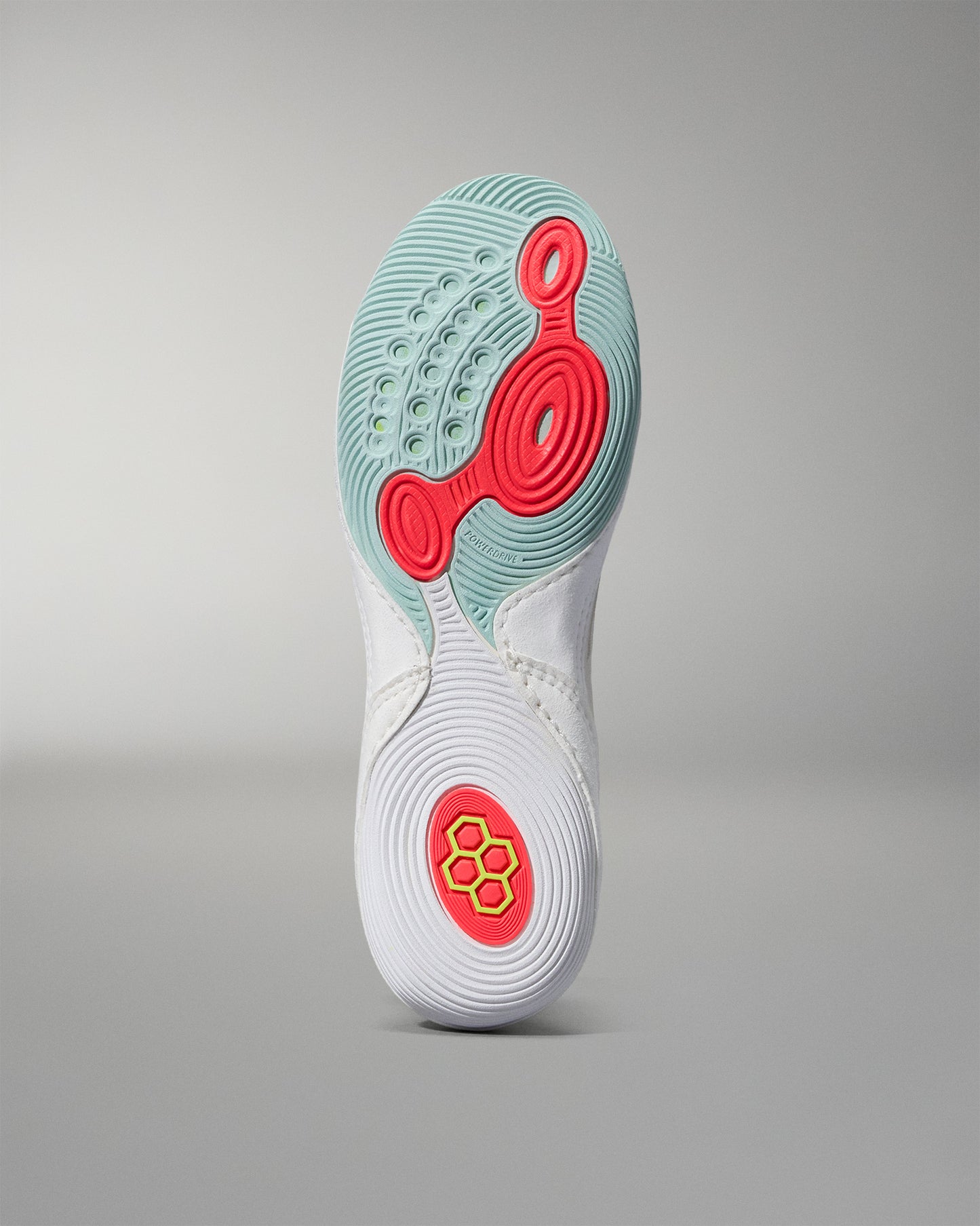 Sole of a white wrestling shoe with red and green accents on a gray background