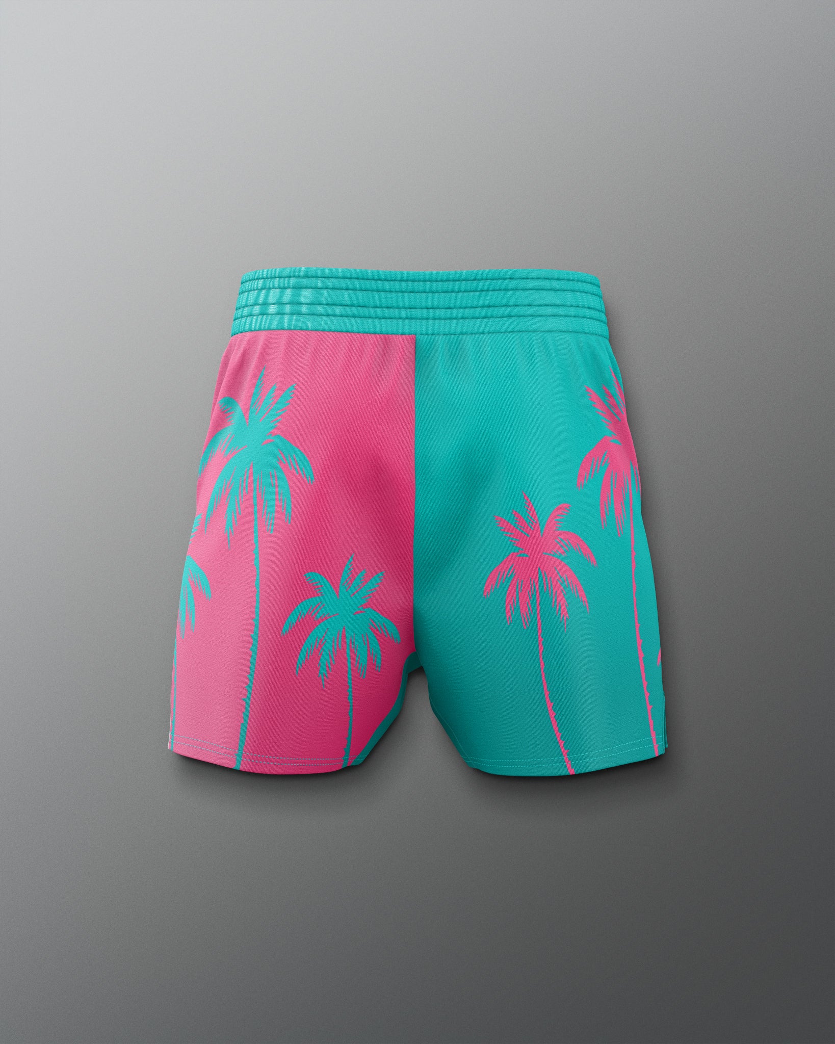 Pink and teal shorts with palm tree design on a gray background