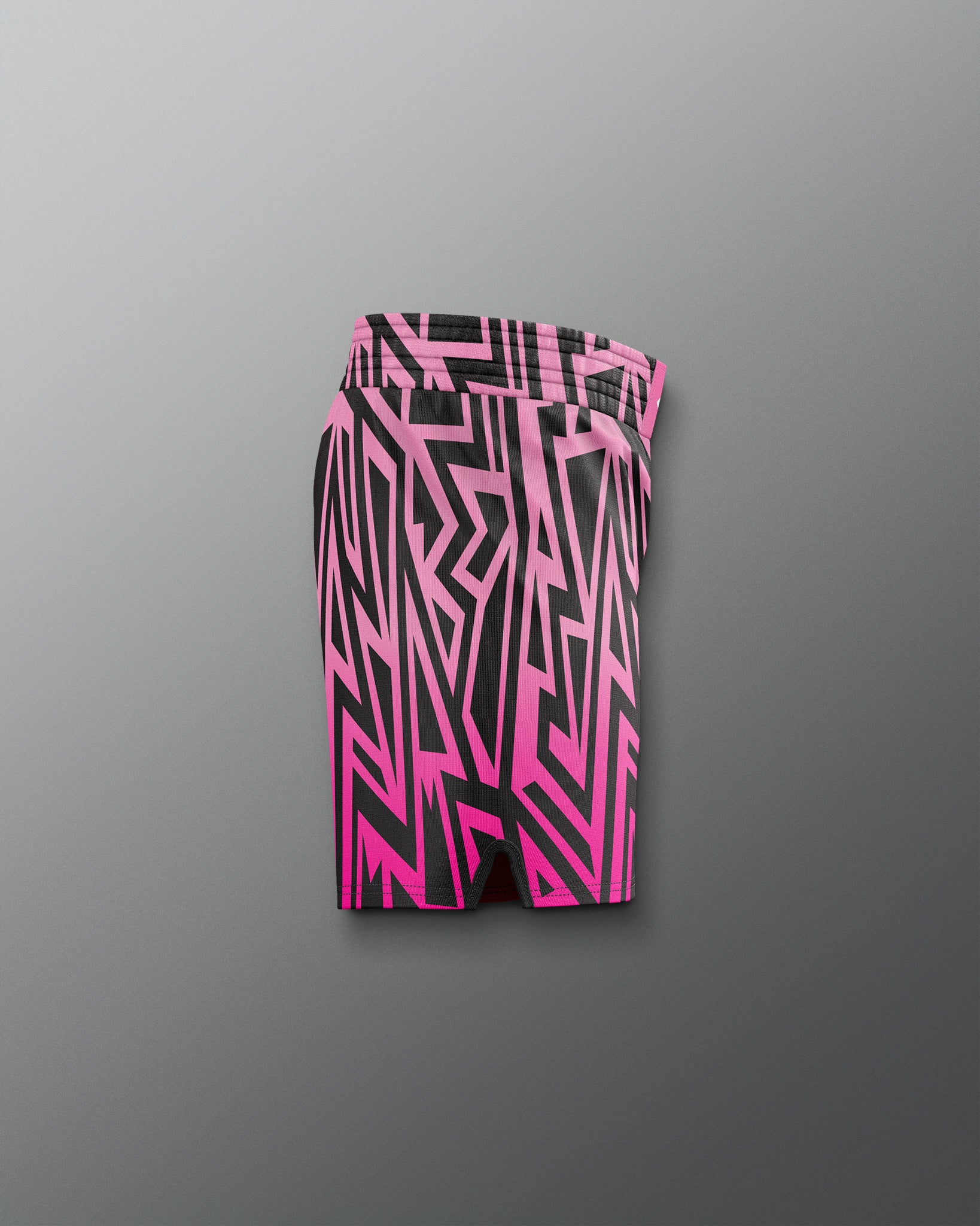 Pink and black geometric patterned shorts on a gray background