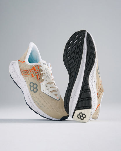 A pair of beige athletic shoes with orange accents showcasing a breathable upper and a textured sole for optimal traction