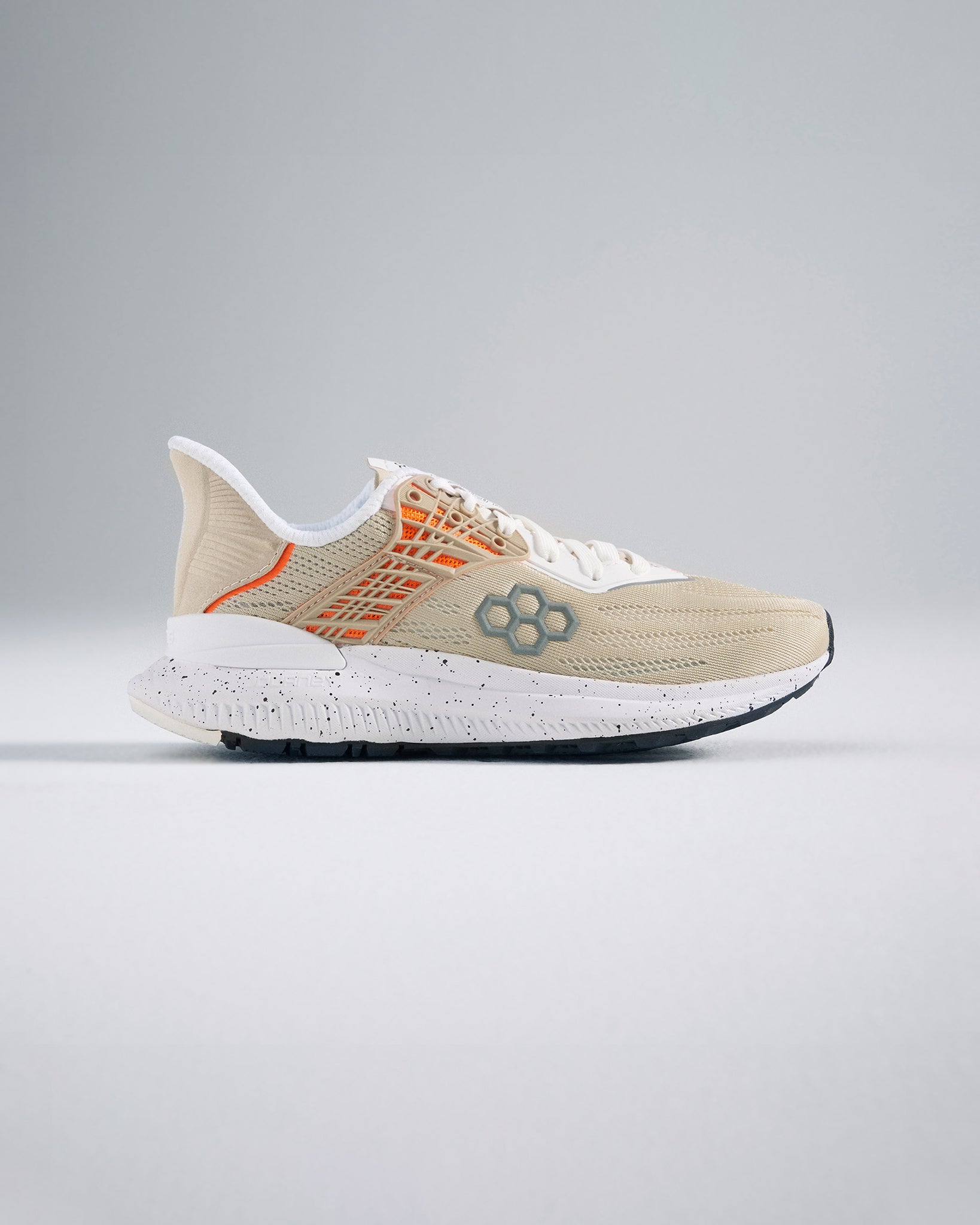 A modern beige athletic shoe highlighting innovative design with breathable mesh and a textured sole for enhanced performance