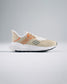A modern beige athletic shoe highlighting innovative design with breathable mesh and a textured sole for enhanced performance