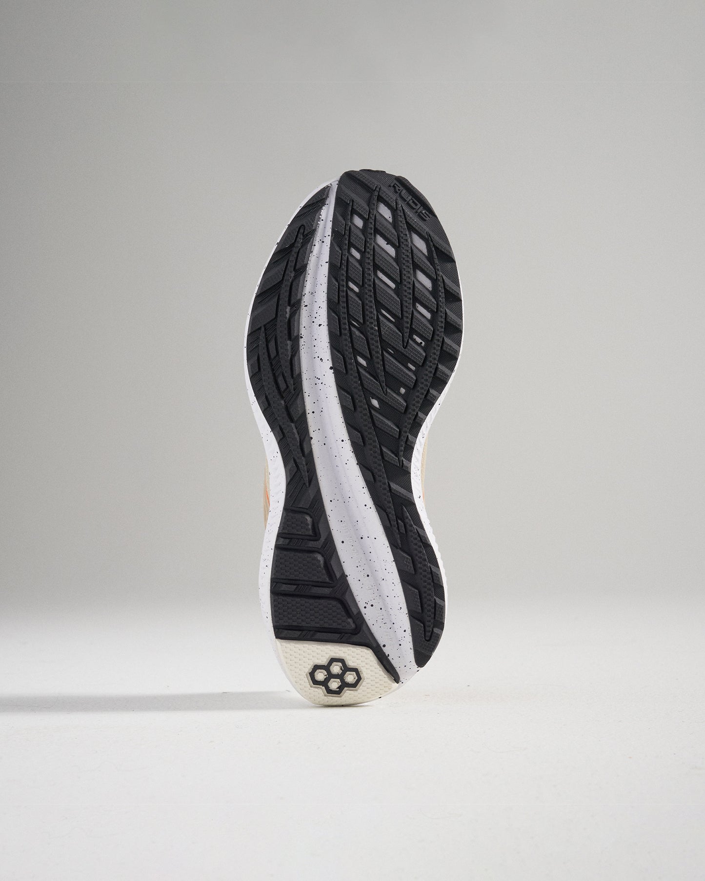 The image displays the outsole of a modern athletic shoe highlighting its intricate tread pattern and construction materials designed for optimal grip and durability