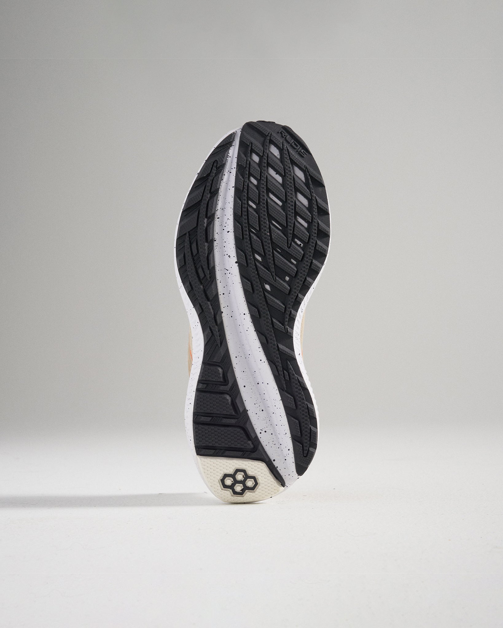 The image displays the outsole of a modern athletic shoe highlighting its intricate tread pattern and construction materials designed for optimal grip and durability