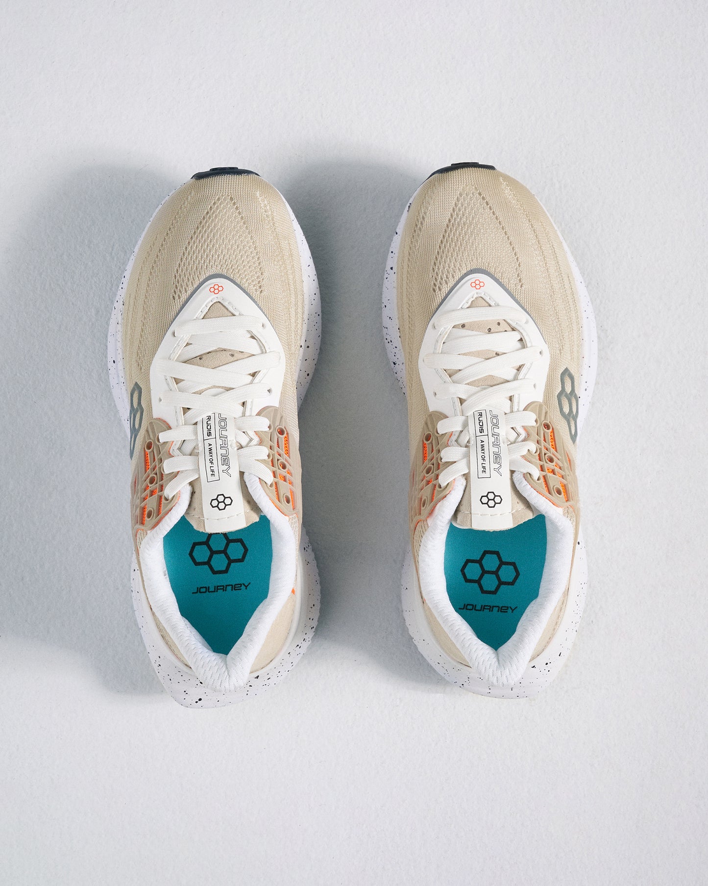 A pair of beige and white athletic shoes with a breathable mesh upper and colorful detailing accompanied by a snug fit for comfort during physical activities