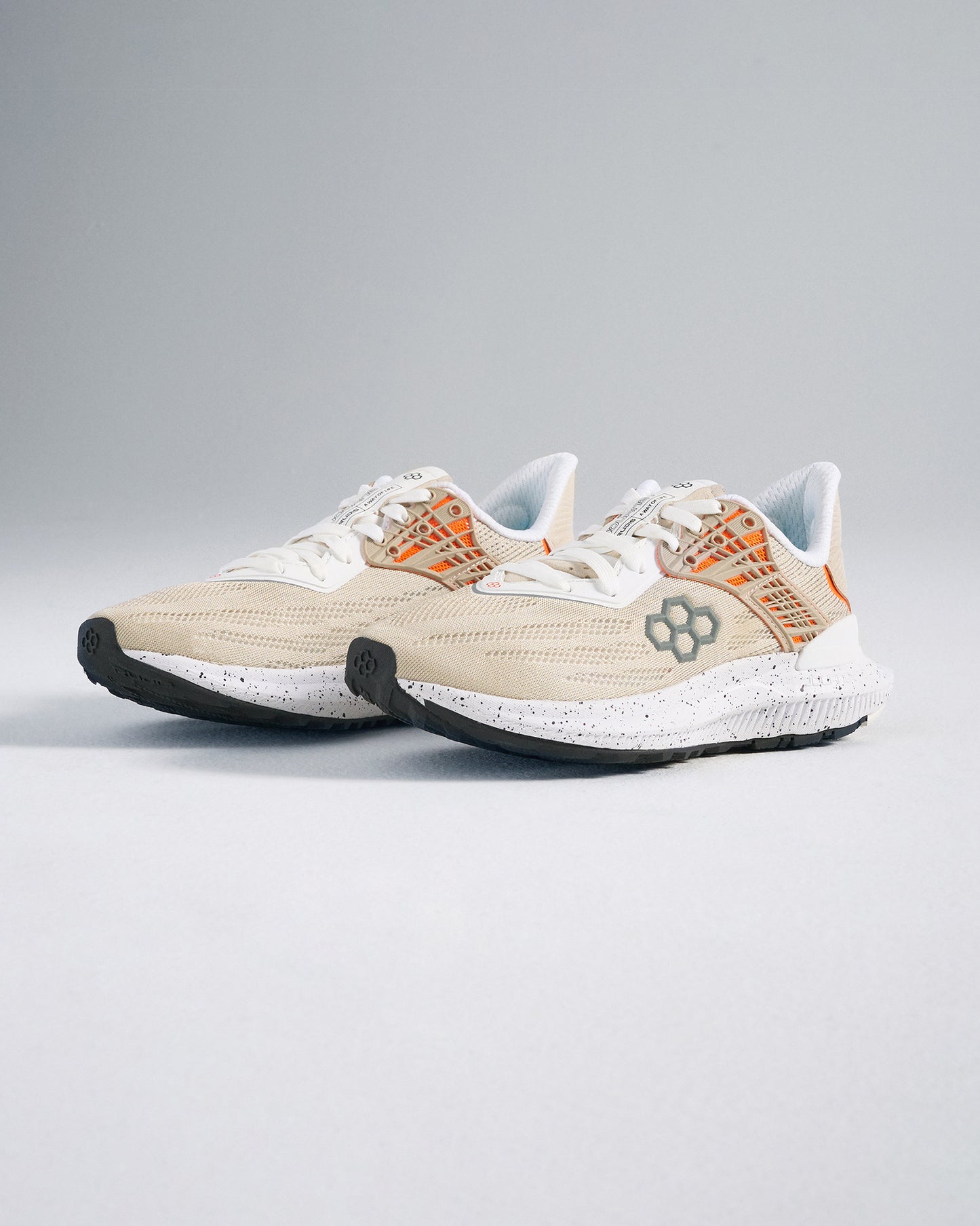 A stylish pair of lightweight beige running shoes featuring a breathable mesh upper with orange styling designed for both comfort and performance