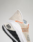 A close-up view of a modern athletic shoe featuring a beige upper with orange accents designed for comfort and performance