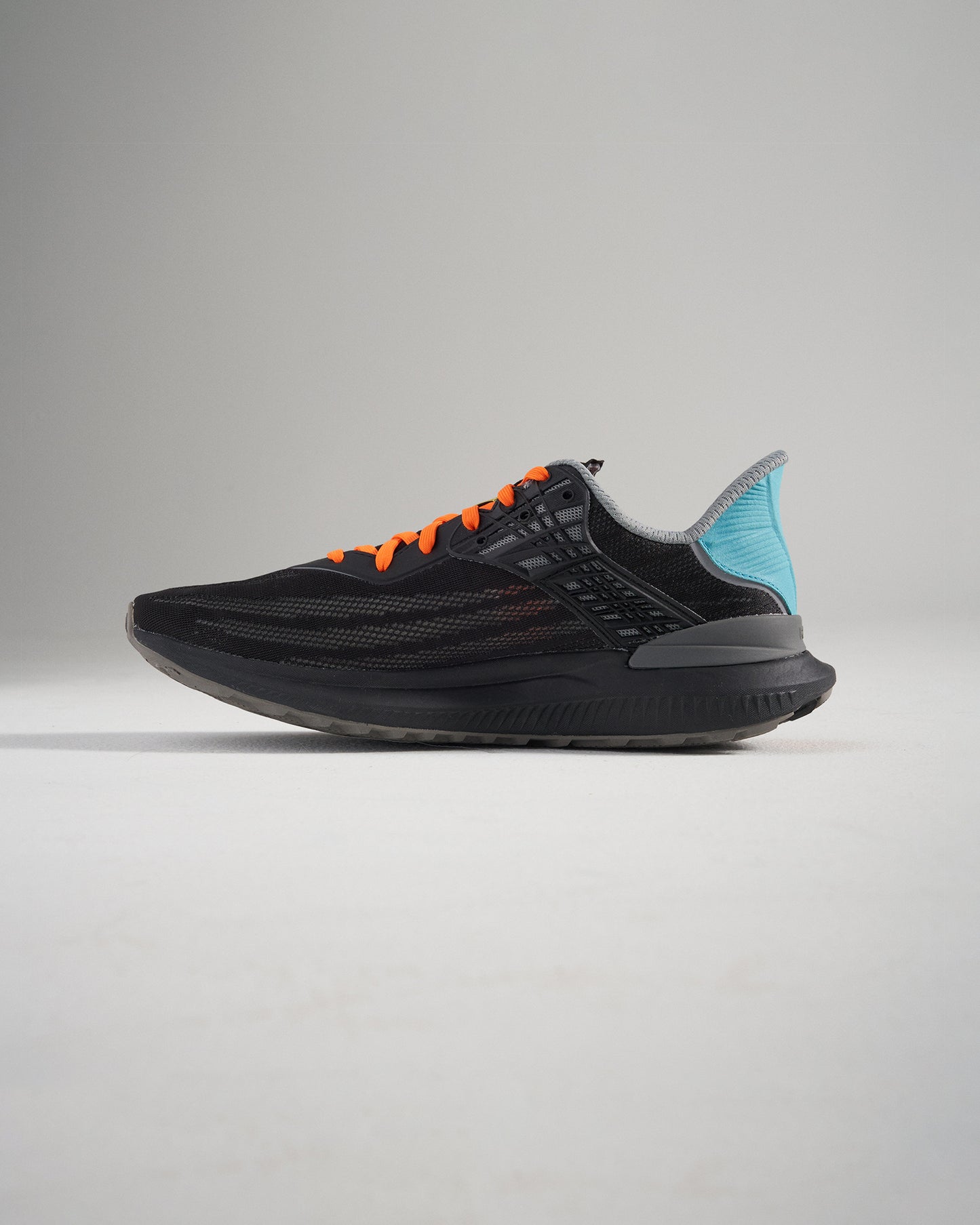 A sleek black running shoe featuring vibrant orange laces and a light blue heel counter designed for both style and performance