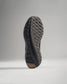 The image displays the sole of a modern athletic shoe featuring a unique tread pattern and a striking orange accent