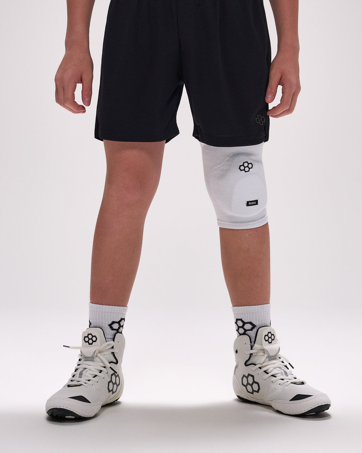 Person wearing a white knee pad on a plain background
