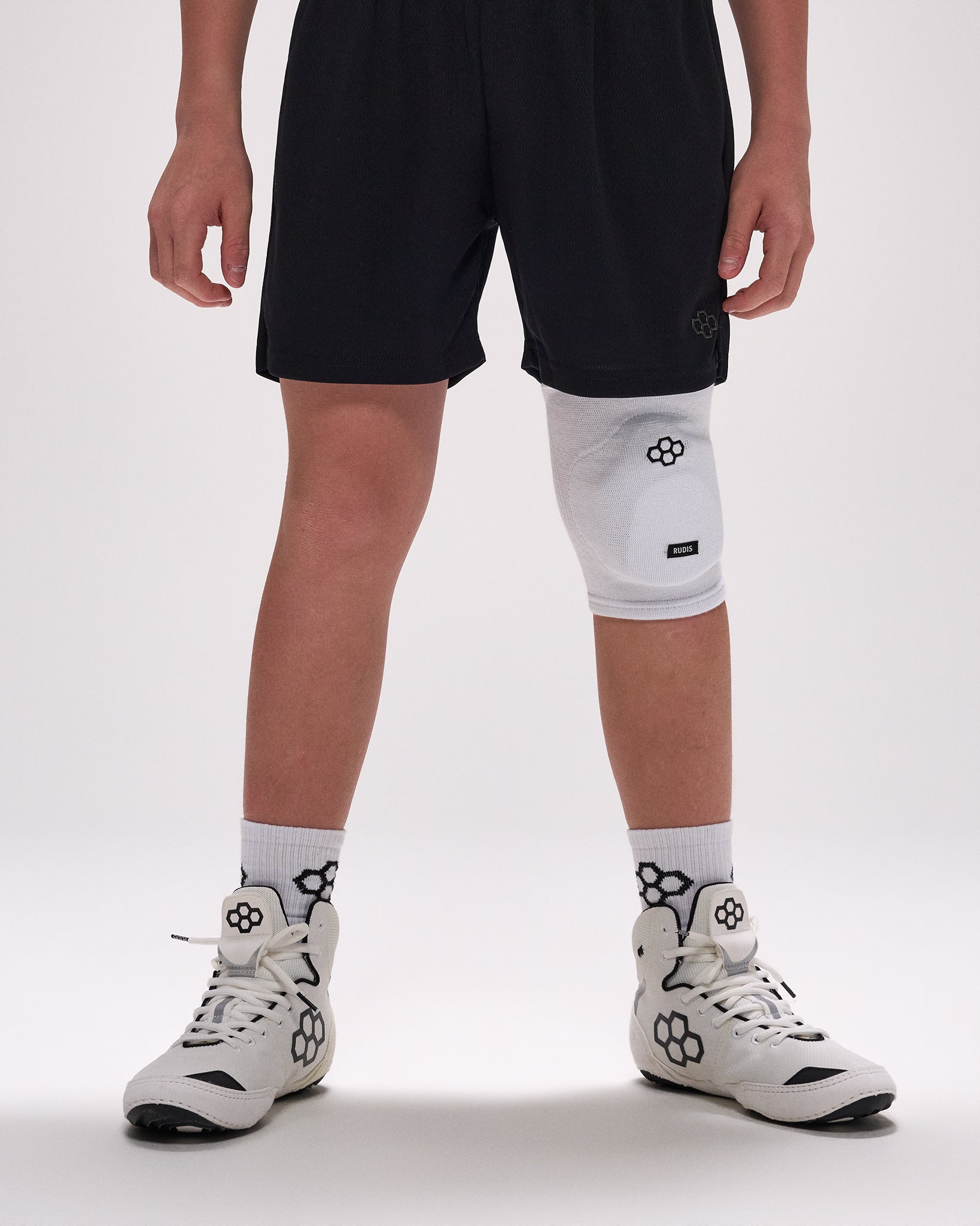 Person wearing a white knee pad on a plain background