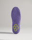 A detailed view of a purple athletic shoes outsole showcasing a unique tread pattern and a distinct hexagonal logo in green