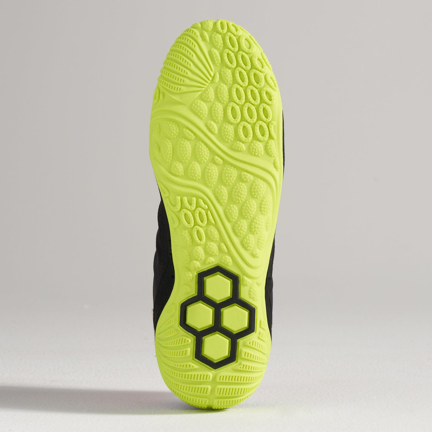 A vibrant black athletic shoe sole featuring a bright yellow outsole with textured patterns for enhanced grip