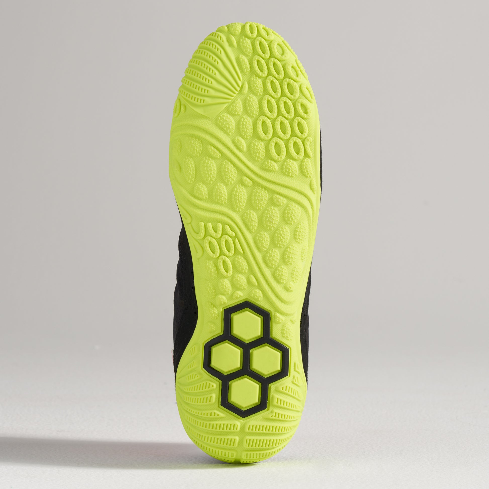 A vibrant black athletic shoe sole featuring a bright yellow outsole with textured patterns for enhanced grip