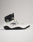 A stylish high-top athletic shoe featuring a mix of white and black colors with vibrant green laces and a textured sole for enhanced performance