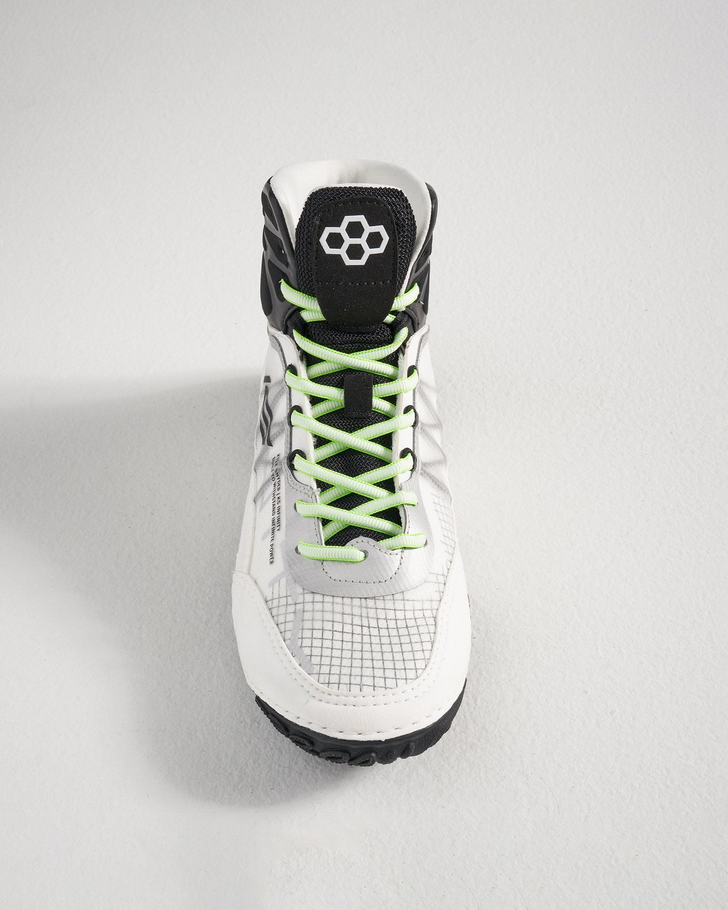 A close-up view of a stylish white athletic shoe featuring vibrant green laces and a textured sole designed for optimal grip