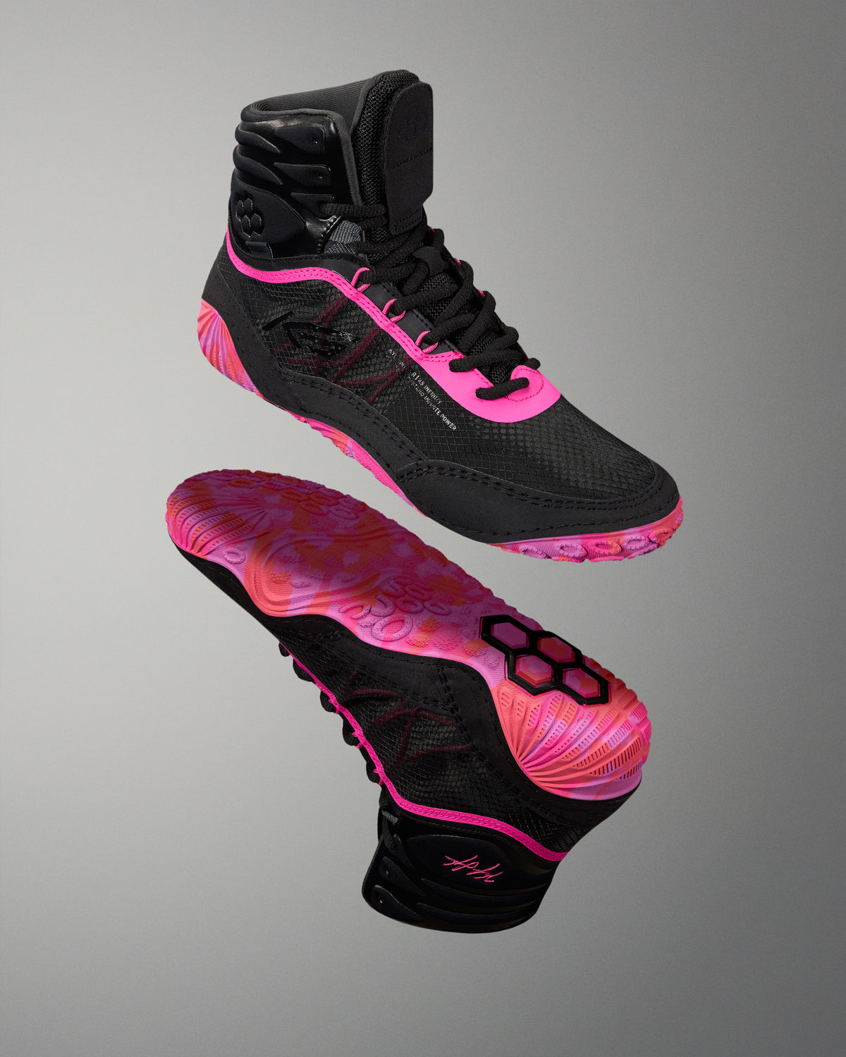 A pair of high-top athletic Wrestling shoes in black with vibrant neon pink accents, shown from both the side and sole views against a neutral gray background.