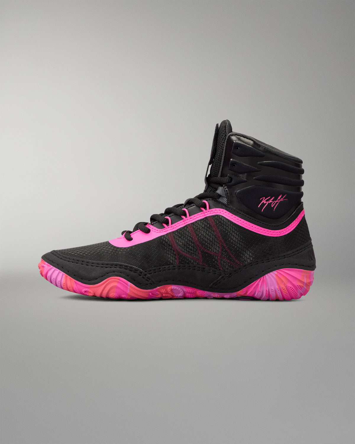 A high-top athletic wrestling shoe in black with vibrant neon pink accents and a matching pink and black wavy sole, shown from a side profile on a neutral gray background.