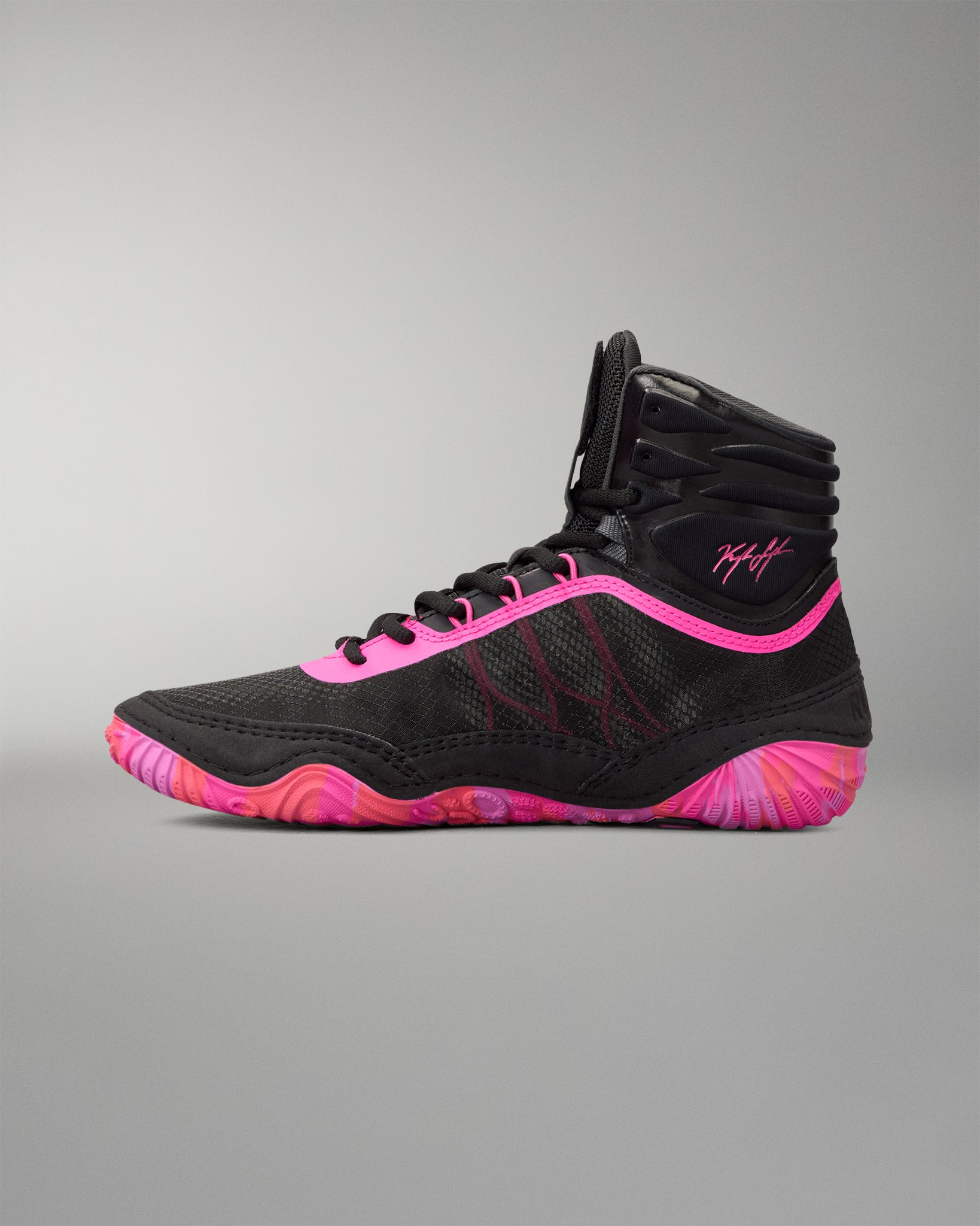 A high-top athletic wrestling shoe in black with vibrant neon pink accents and a matching pink and black wavy sole, shown from a side profile on a neutral gray background.