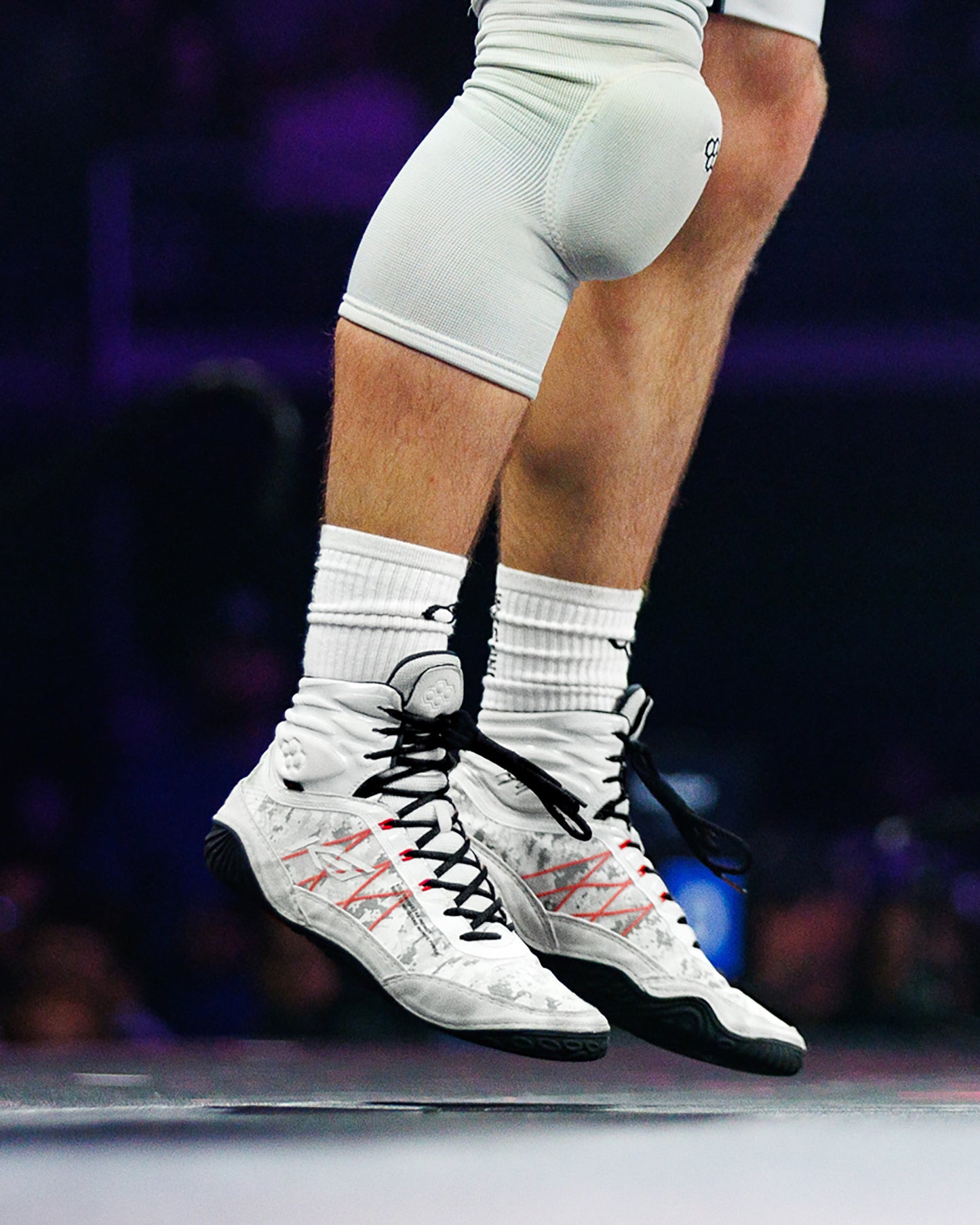 Athlete competing in white and gray RUDIS wrestling shoes with black laces and red performance detailing