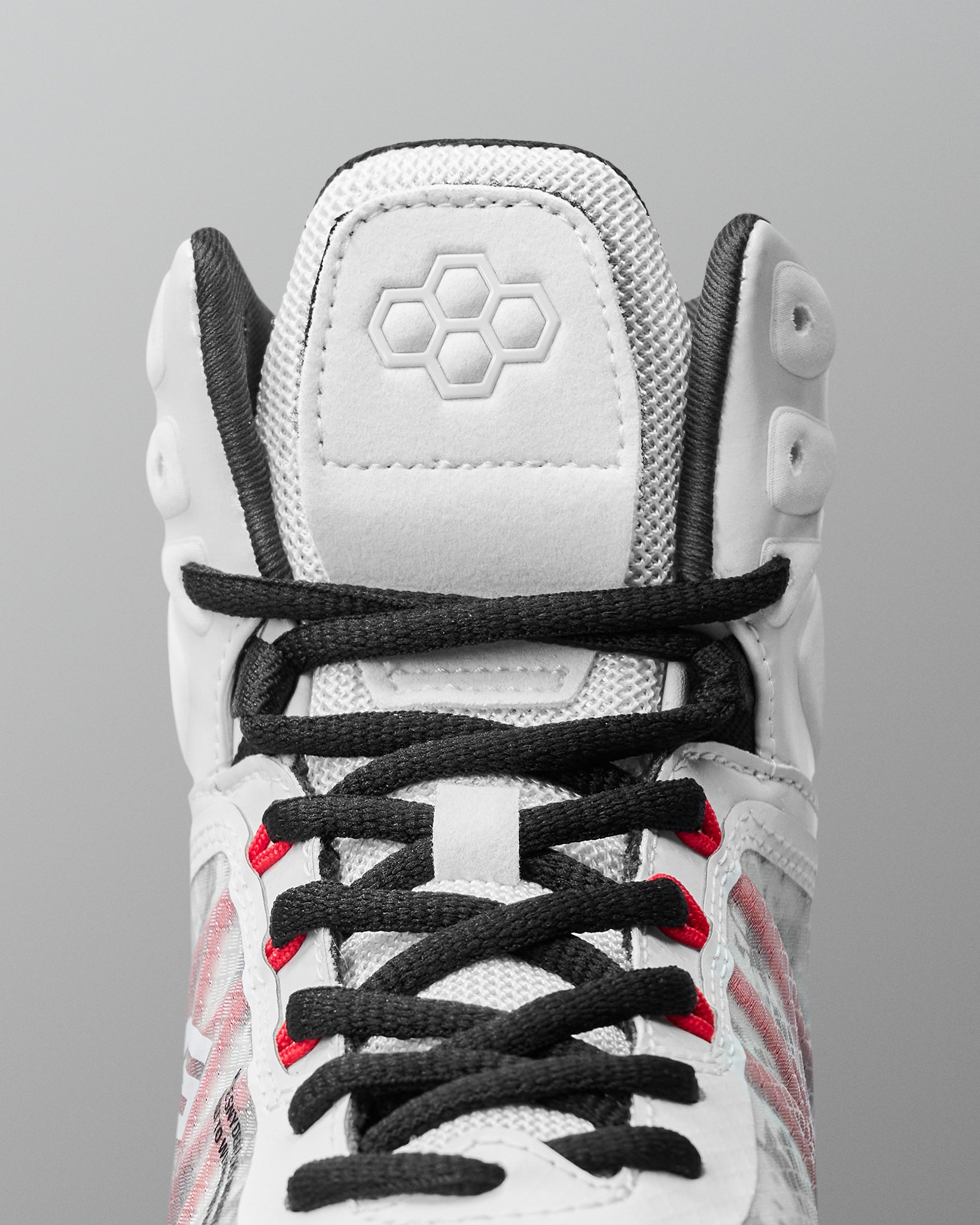 Close-up detail of RUDIS Infinity Edge wrestling shoe lacing system with black laces and red performance eyelets