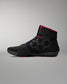Black wrestling shoe with red accents on a gray background