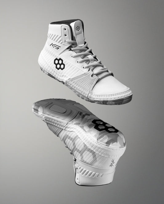 White wrestling shoes with black logo on a gray background