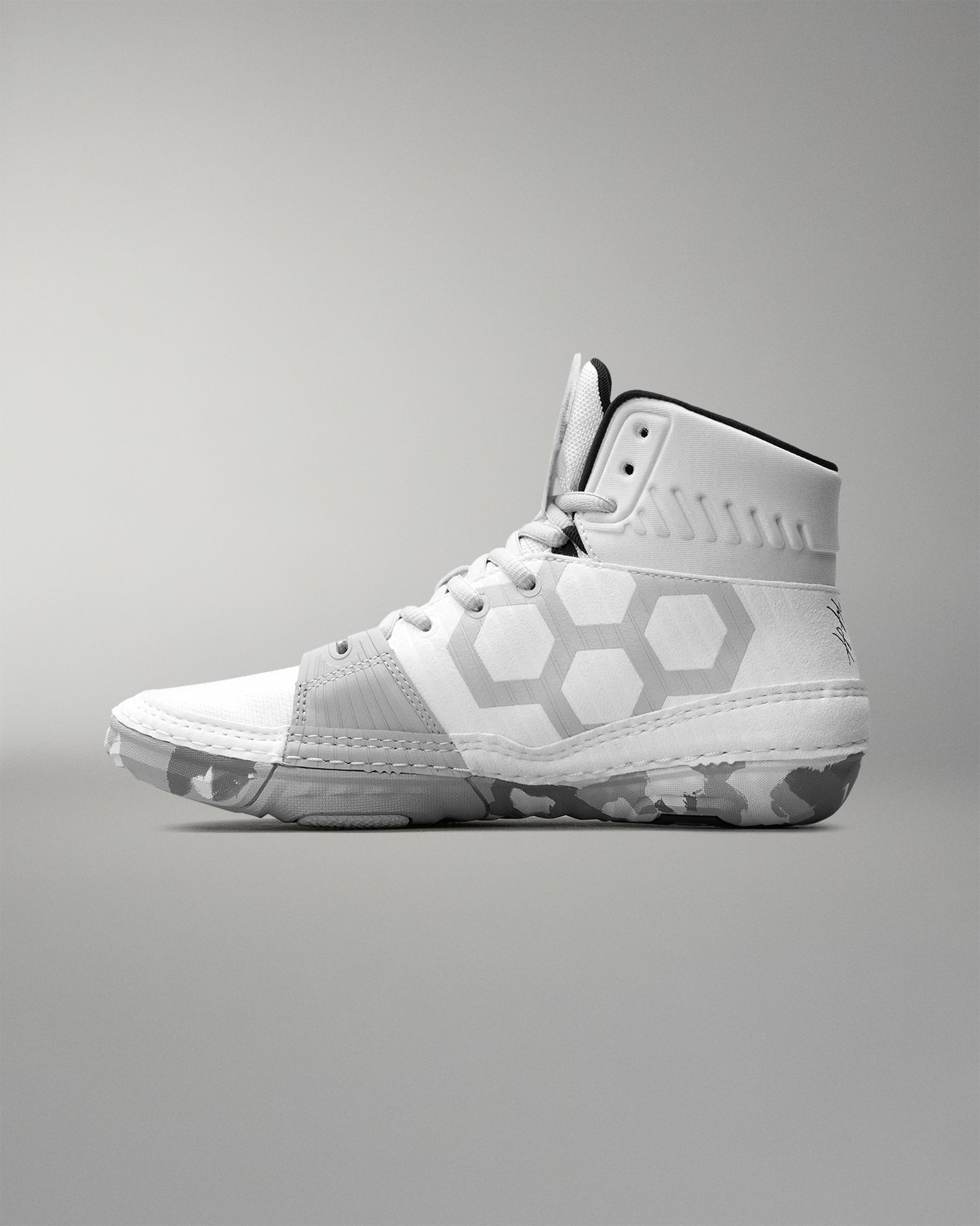 White wrestling shoe with geometric design on a gray background
