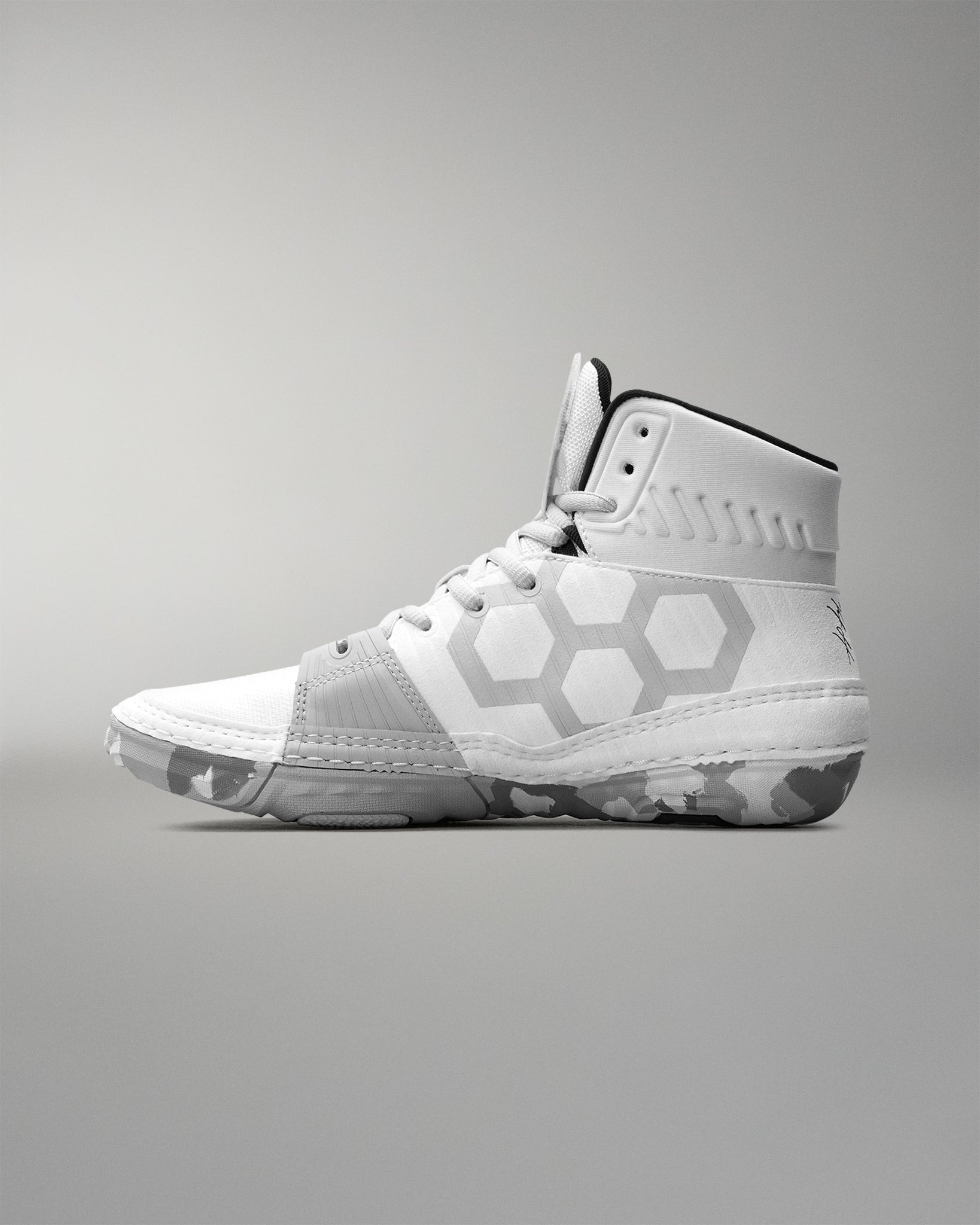 White wrestling shoe with geometric design on a gray background