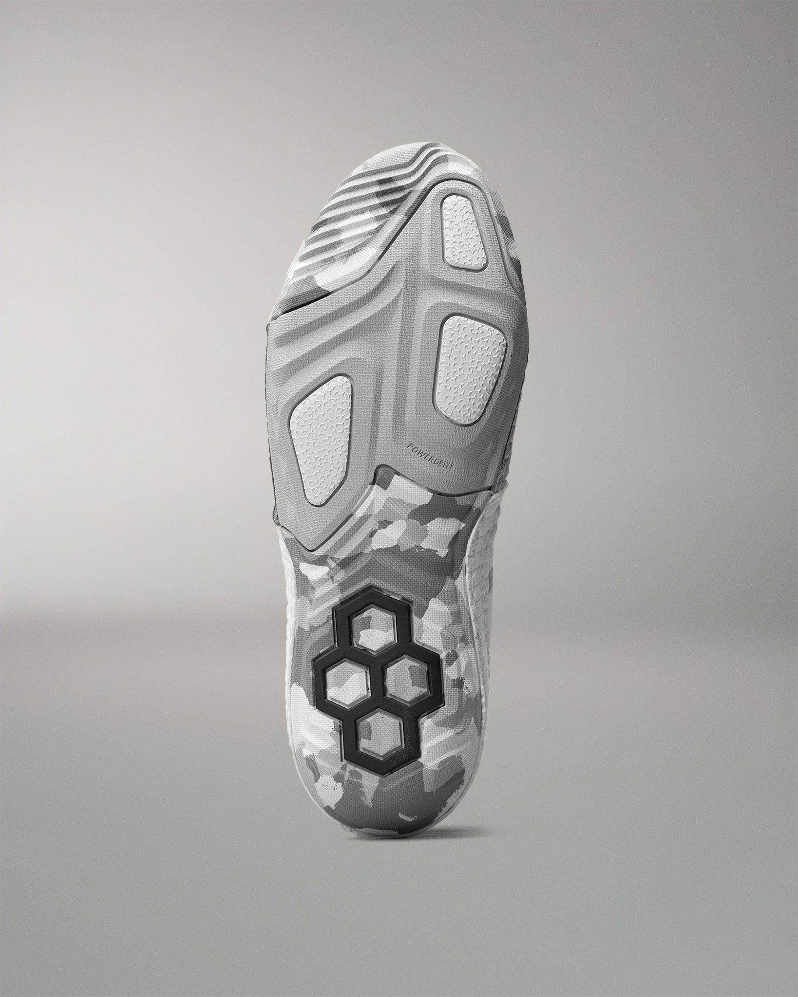 Gray wrestling shoe with unique sole design on a gray background