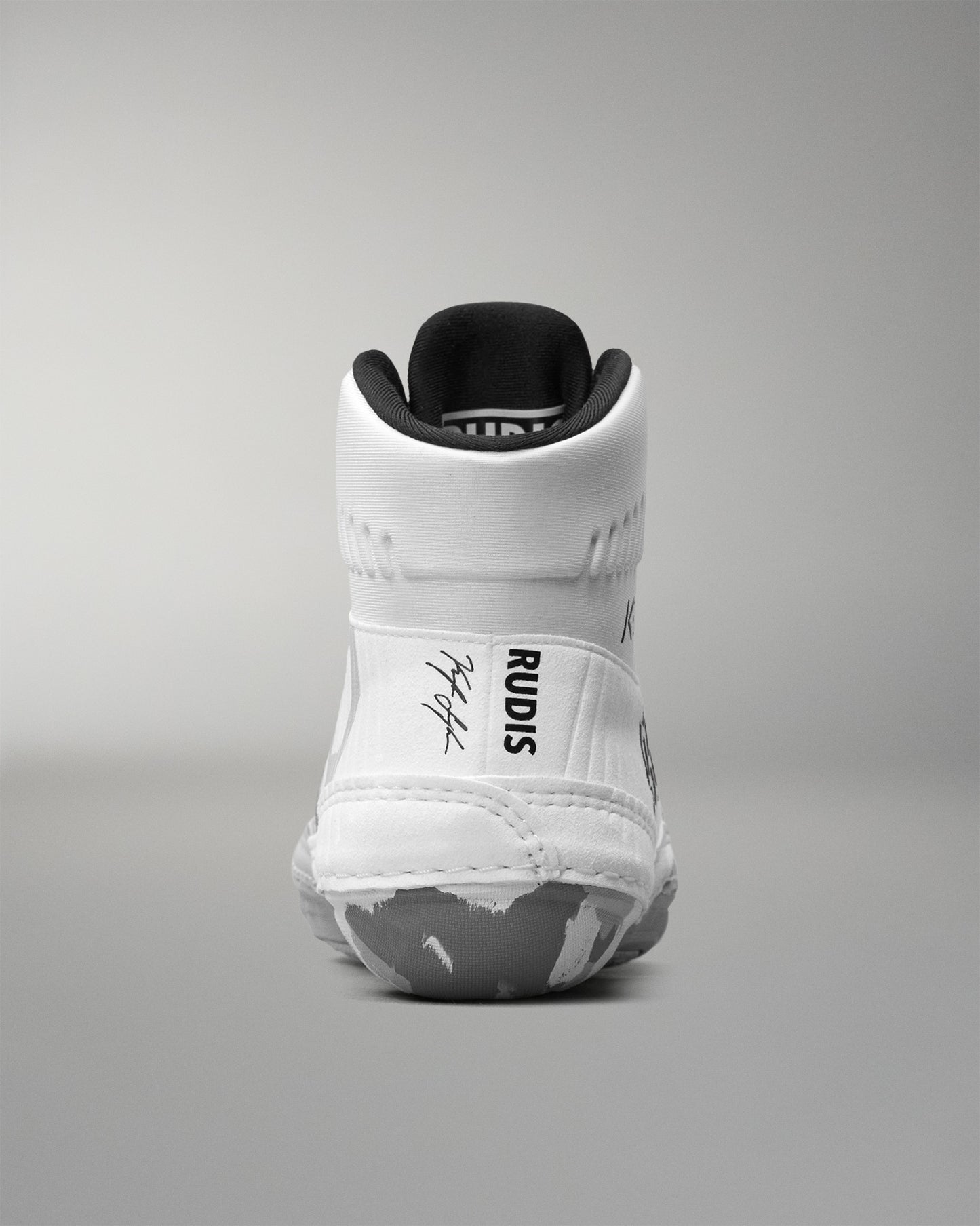 White wrestling shoe with black sole on a gray background