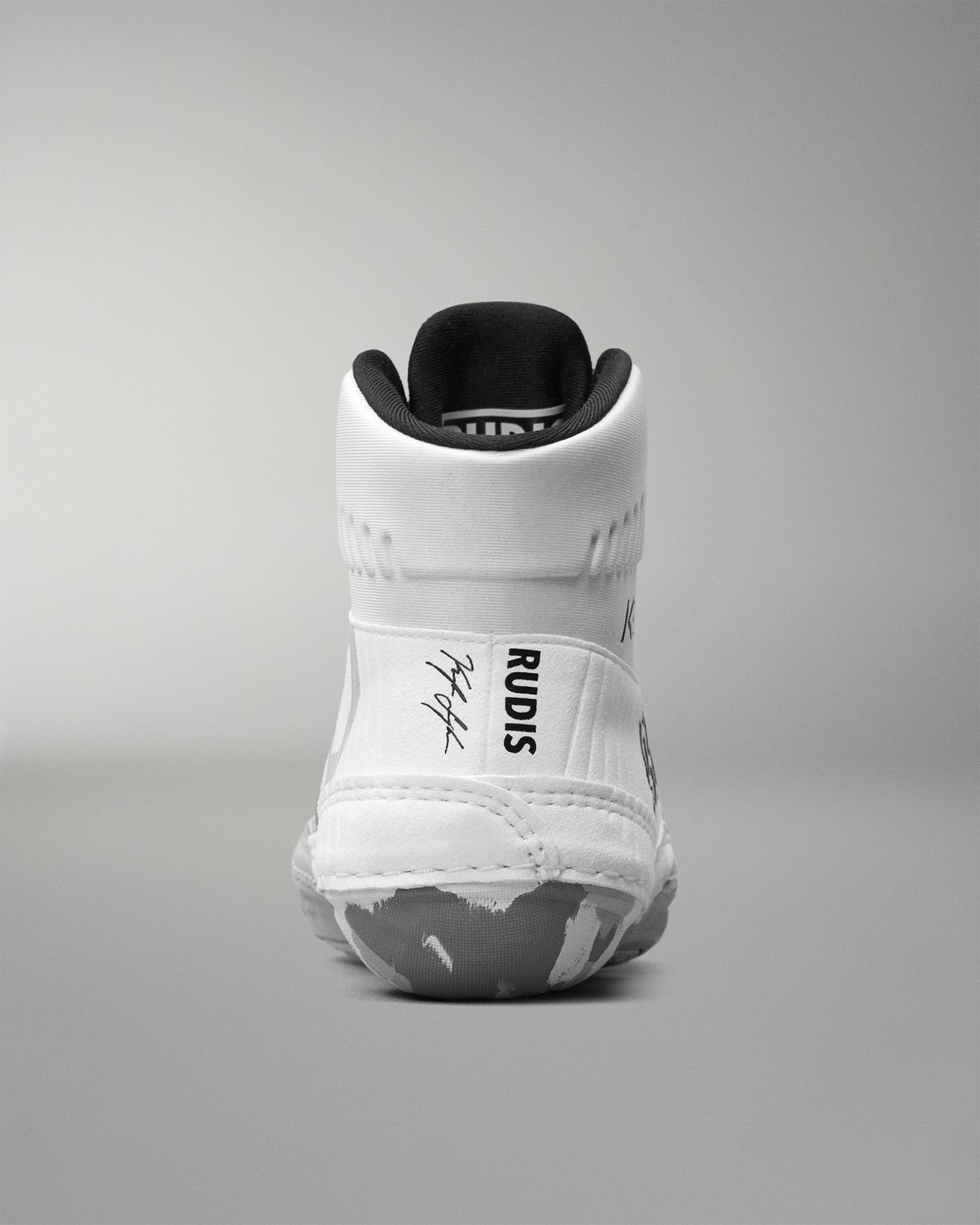 White wrestling shoe with black sole on a gray background
