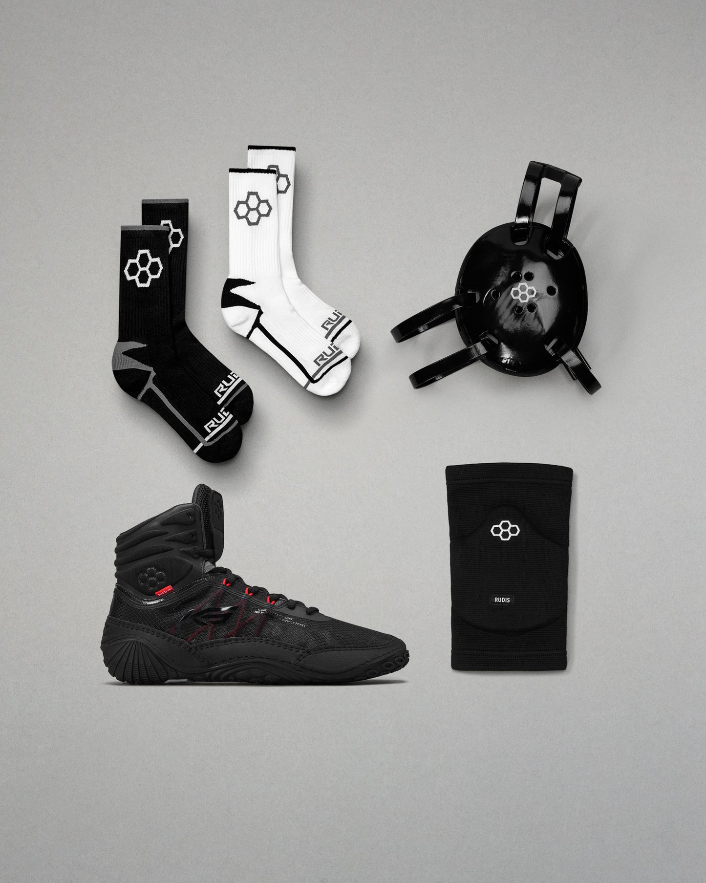 Collection of black and white wrestling shoes, socks, and accessories on a gray background