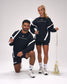Male and female athletes wearing the RUDIS Lacrosse Colorblock Crewneck in Blackout, showcasing premium athletic fleece with modern colorblock panels while holding lacrosse sticks.