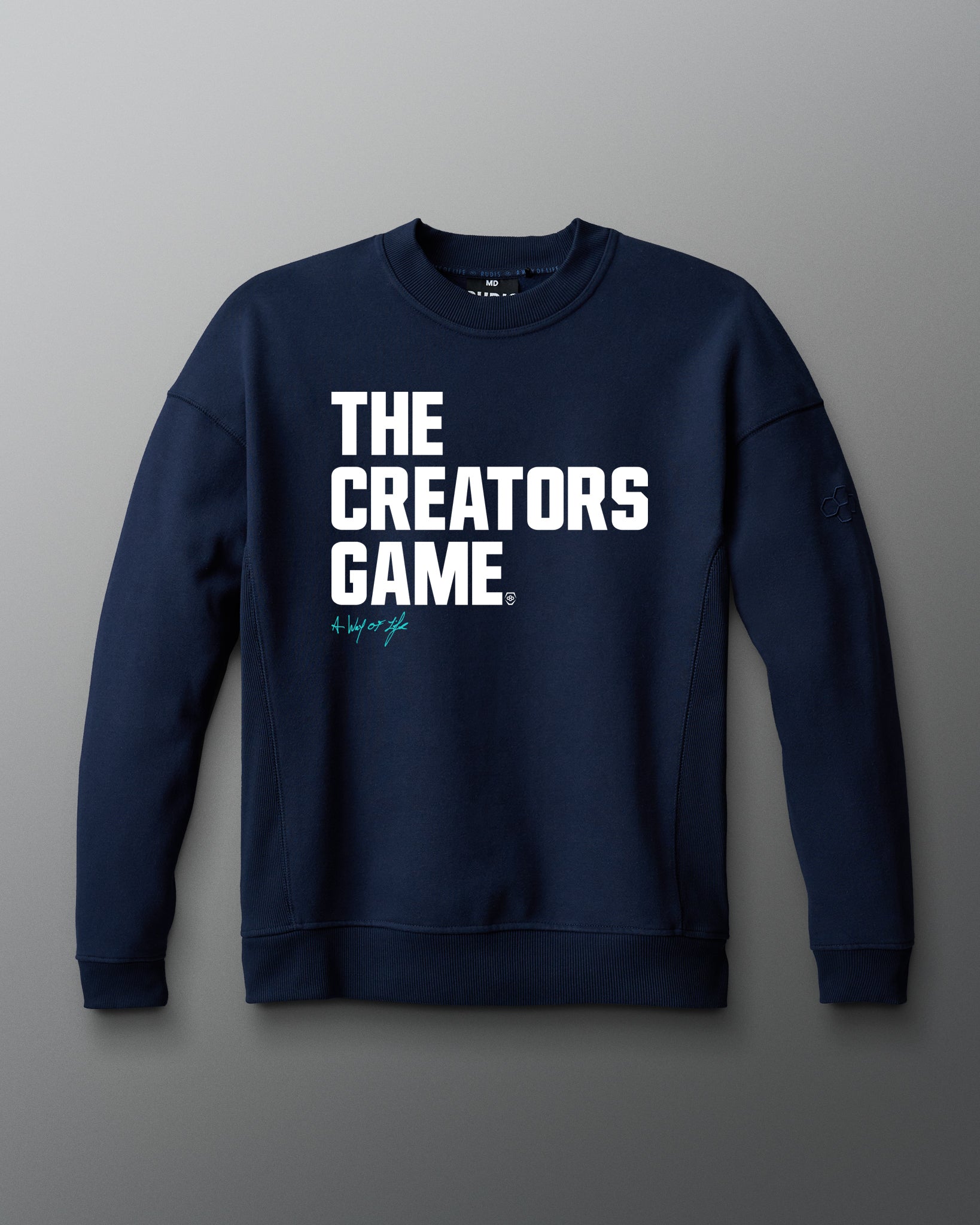 Navy blue sweatshirt with 'THE CREATORS GAME' text on a gray background