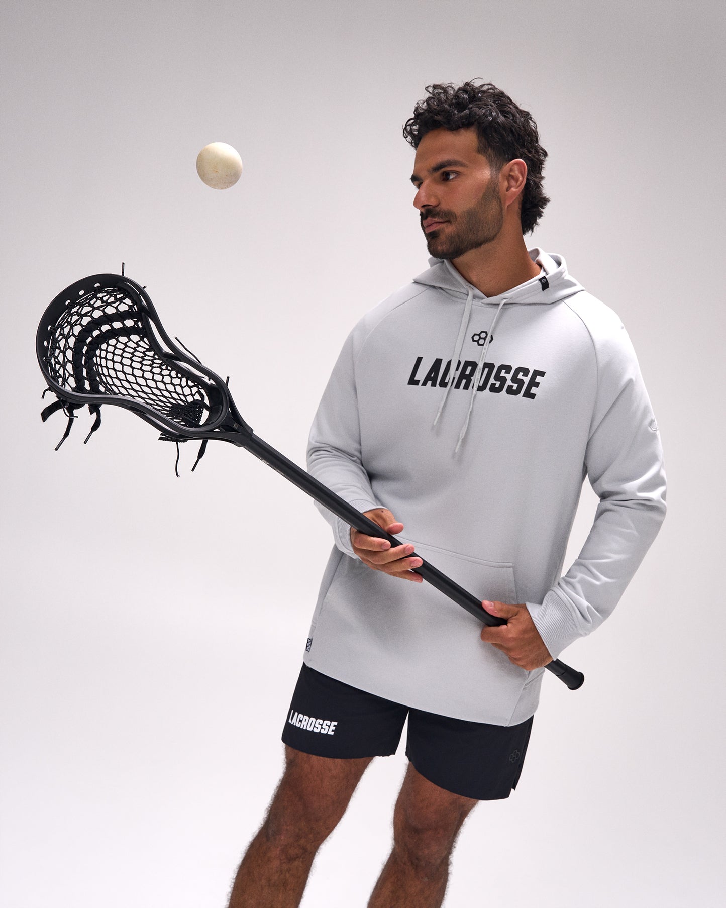 Male athlete wearing the RUDIS Lacrosse Elite Terry Hoodie in Lunar while holding a lacrosse stick and ball, highlighting premium comfort and everyday athletic style.