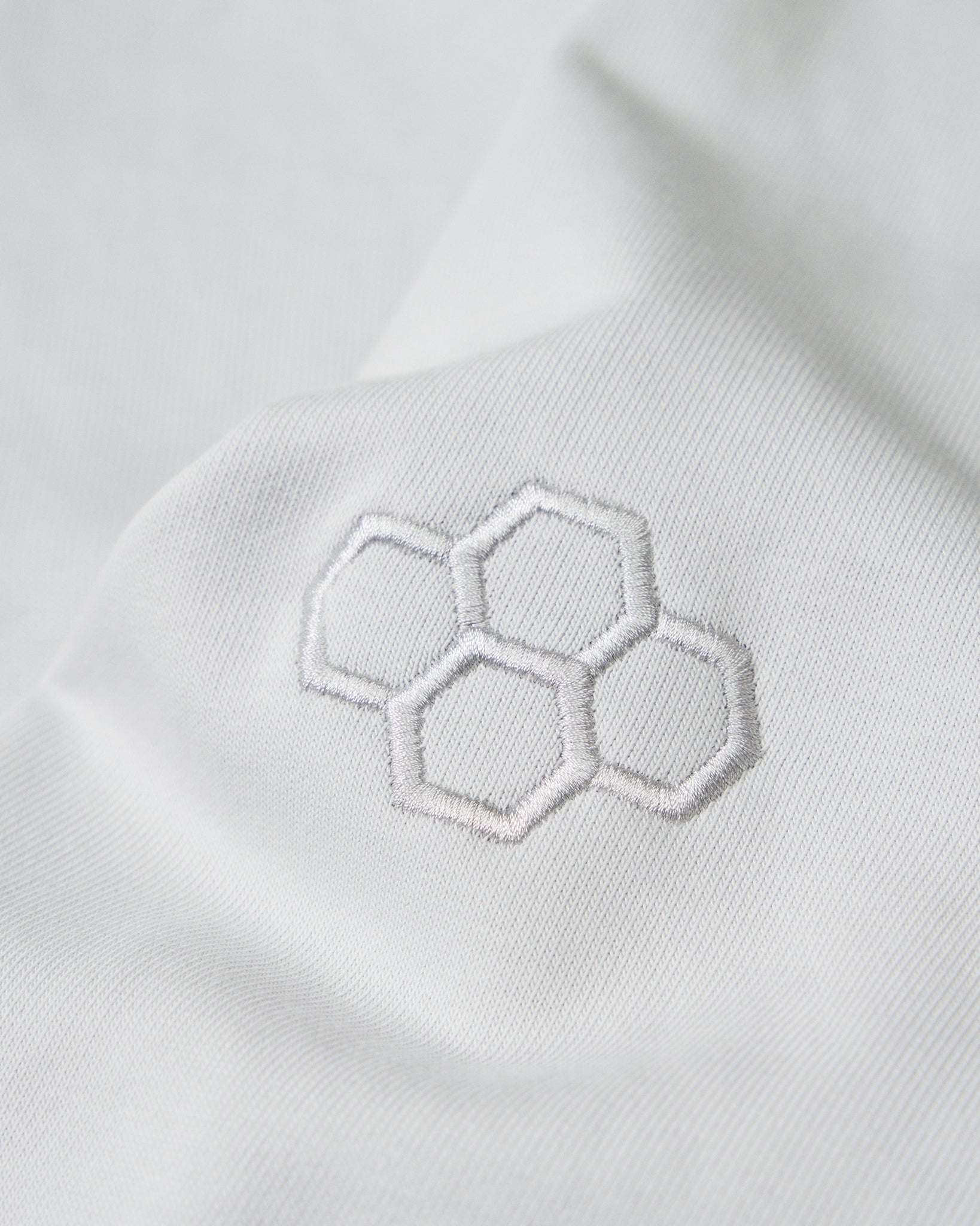 Close-up of the embroidered RUDIS hex logo on the sleeve of the Lunar Lacrosse Elite Terry Hoodie, highlighting premium craftsmanship and clean athletic styling.