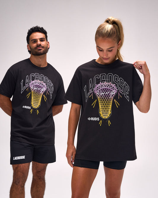 Male and female athletes wearing the RUDIS Motto Lacrosse Heavyweight T-Shirt in Black featuring oversized heavyweight cotton construction and bold lacrosse net graphic with "Lacrosse A Way of Life" artwork.