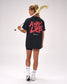 Female athlete wearing the RUDIS The Creator's Game Hybrid T-Shirt in Black featuring oversized "A Way of Life" graphic artwork across the back while carrying a lacrosse stick.