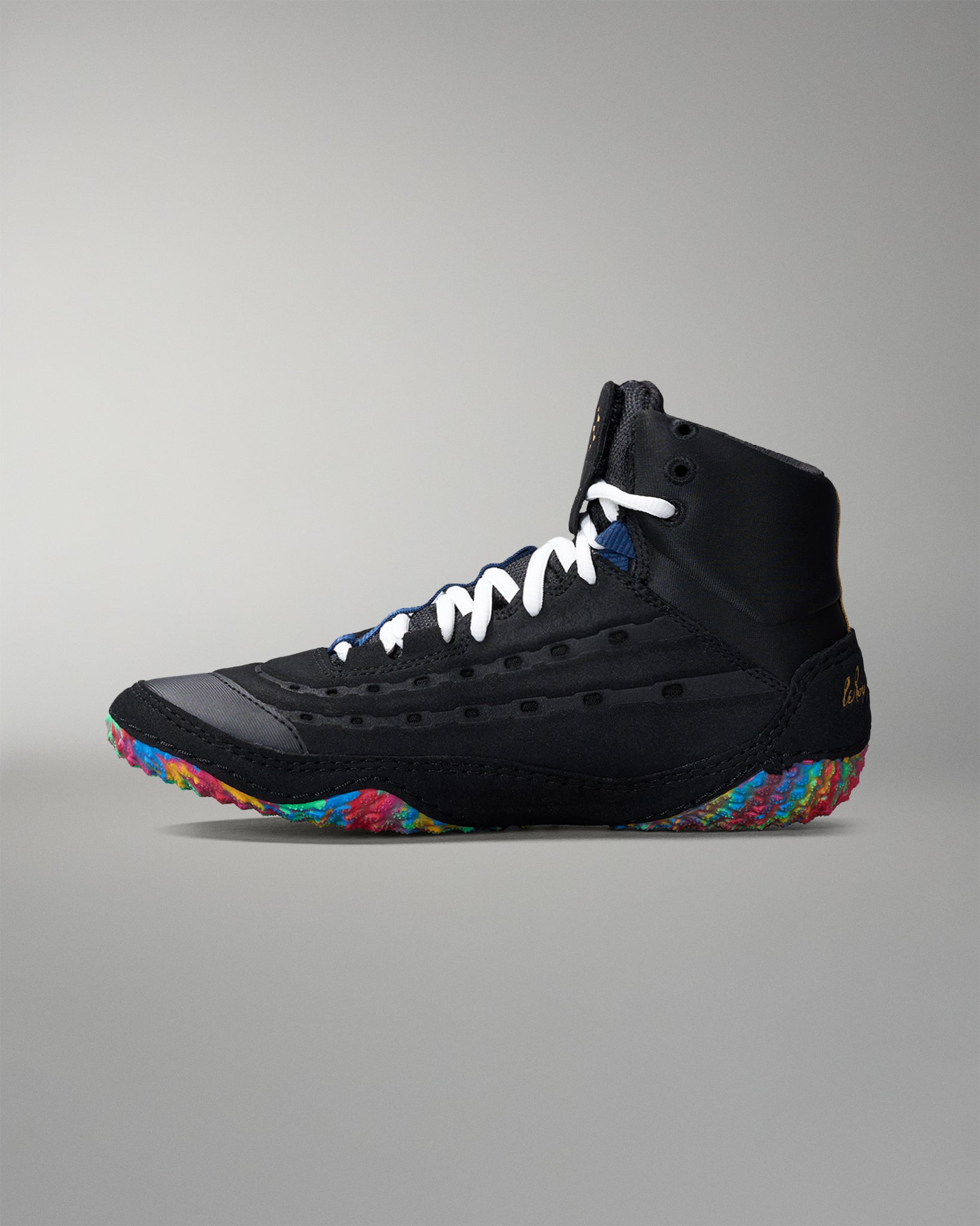 Black wrestling shoe with colorful sole on a gray background