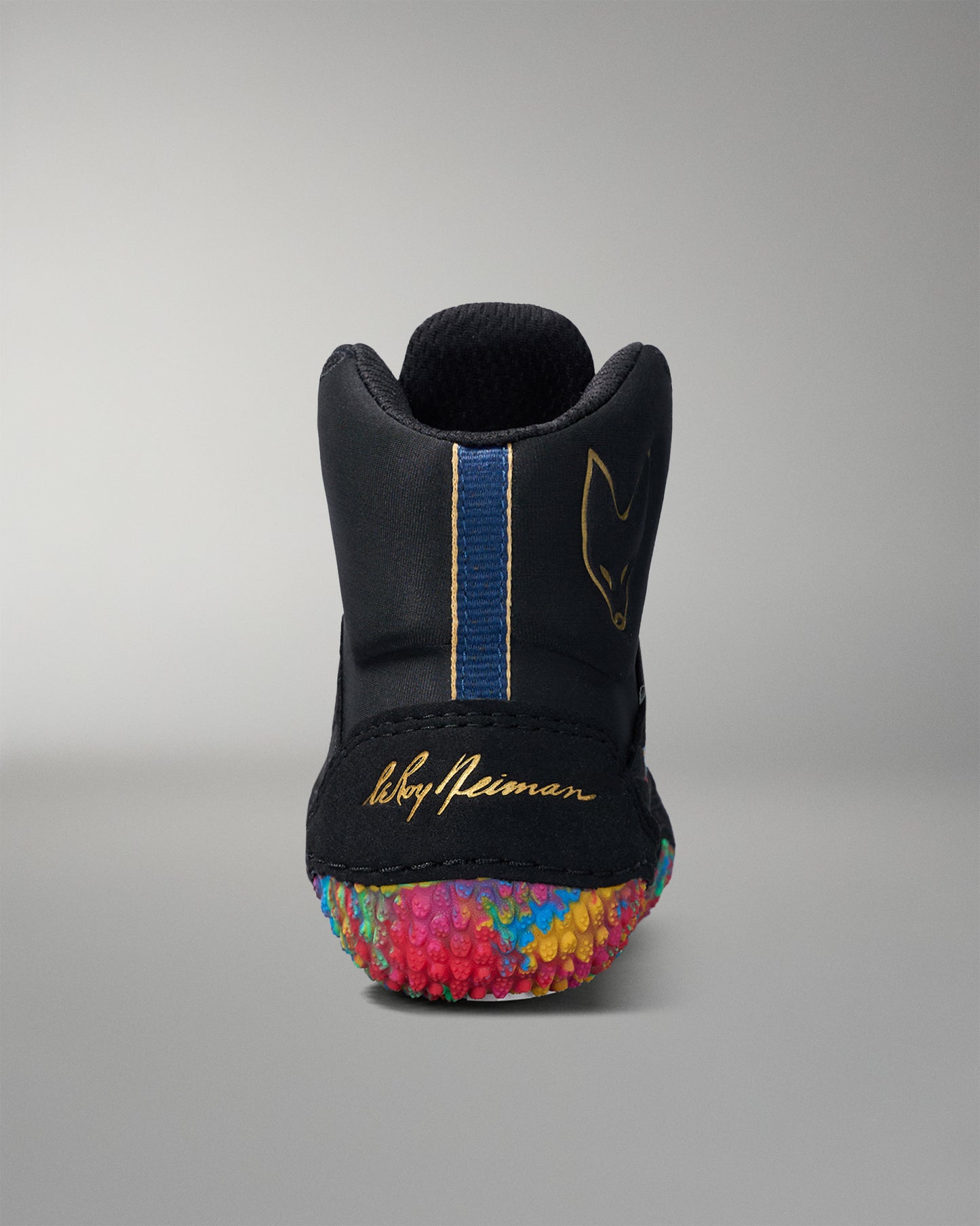 Black wrestling shoe with colorful sole and visible brand name on a gray background