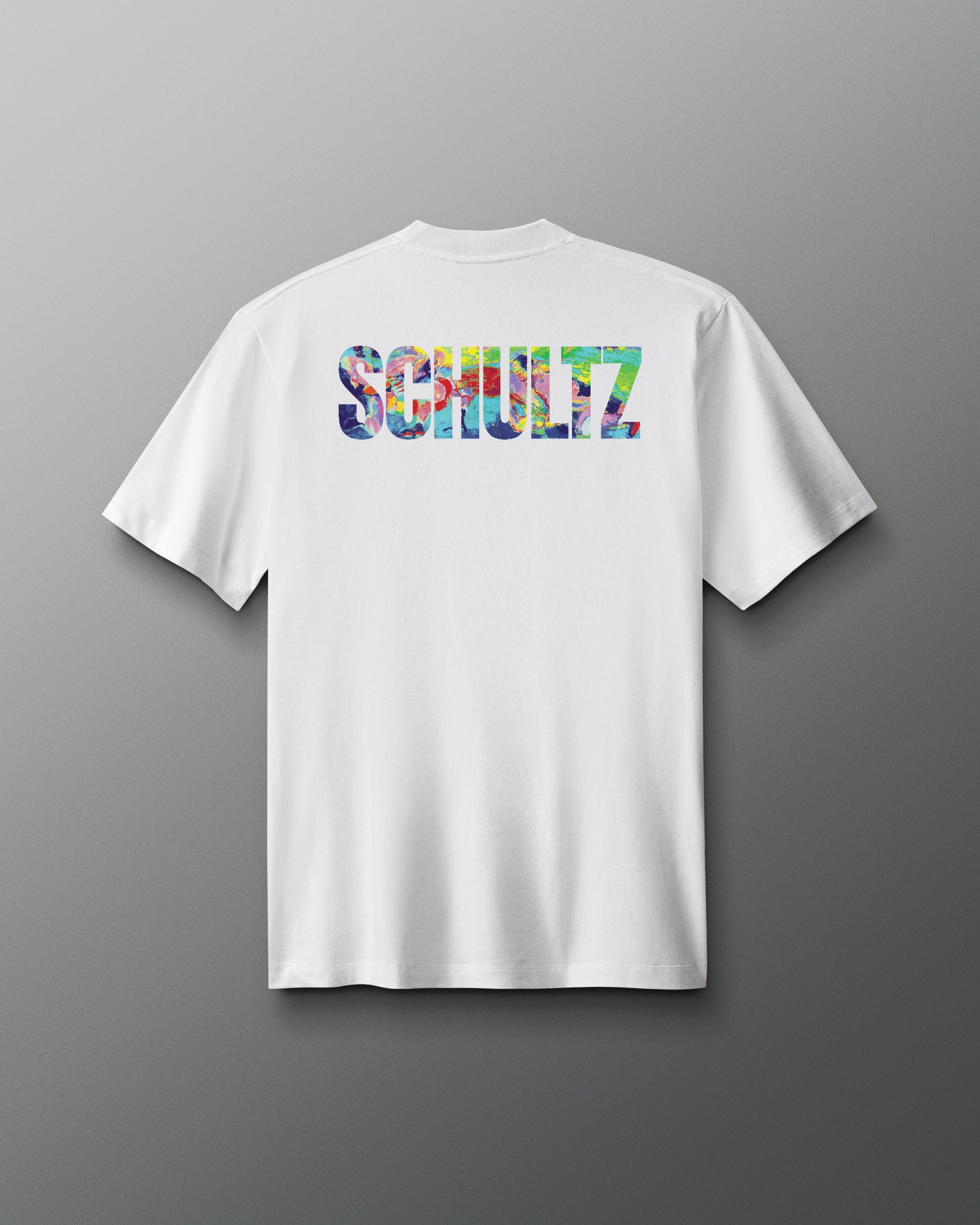 White t-shirt with colorful 'SCHULTZ' logo on the back against a gray background