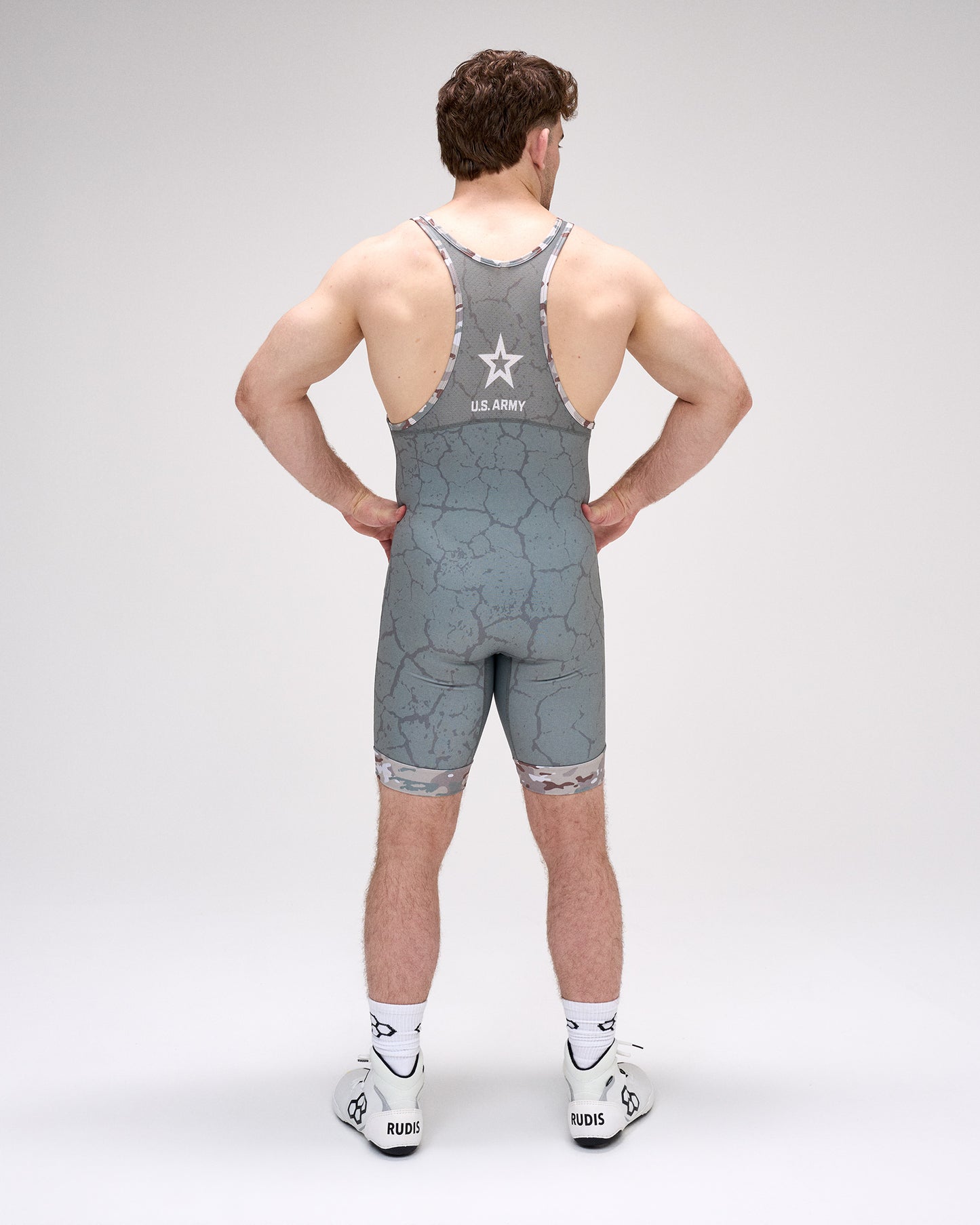 Person wearing a gray wrestling singlet with star design on a white background