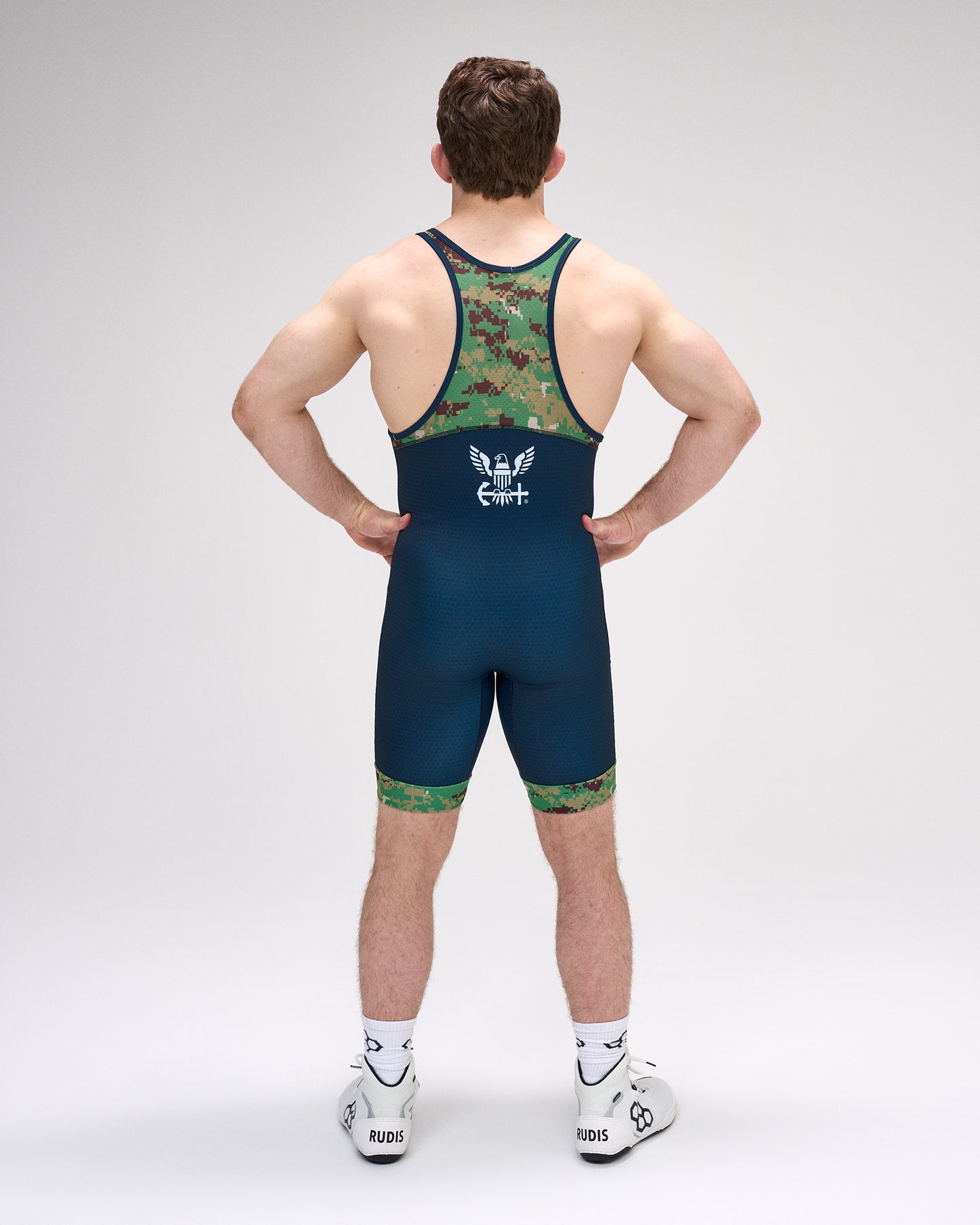 Person wearing a blue and green wrestling singlet on a gray background